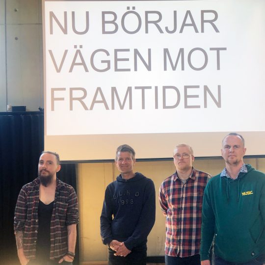 Fyra personer framför texten "Nu börjar vägen mot framtiden"